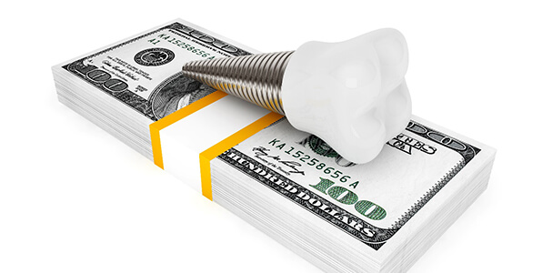 Dental implant in Waupun and Beaver Dam resting on money