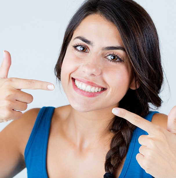 woman pointing to smile with both hands