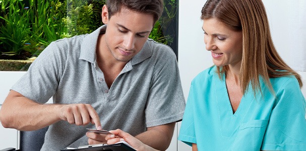 A man using his credit card to pay for dental care
