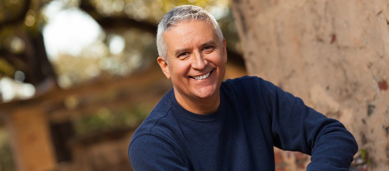 man wearing blue sweater smiling