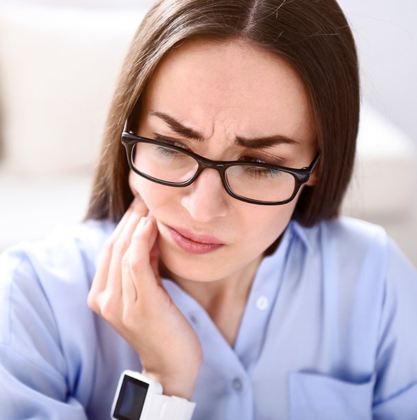 woman holding cheek worried