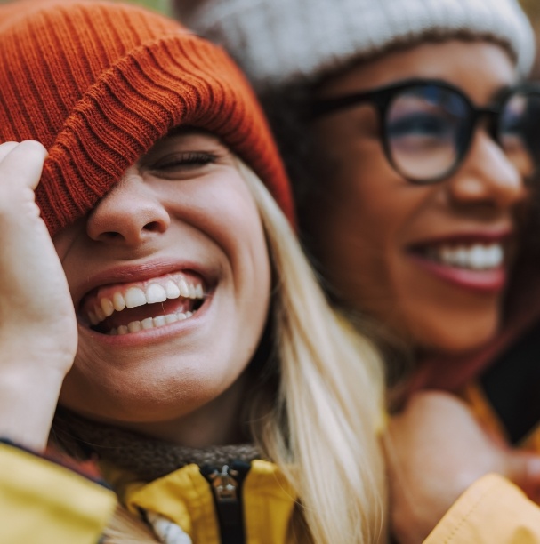 woman covering eye with beanie