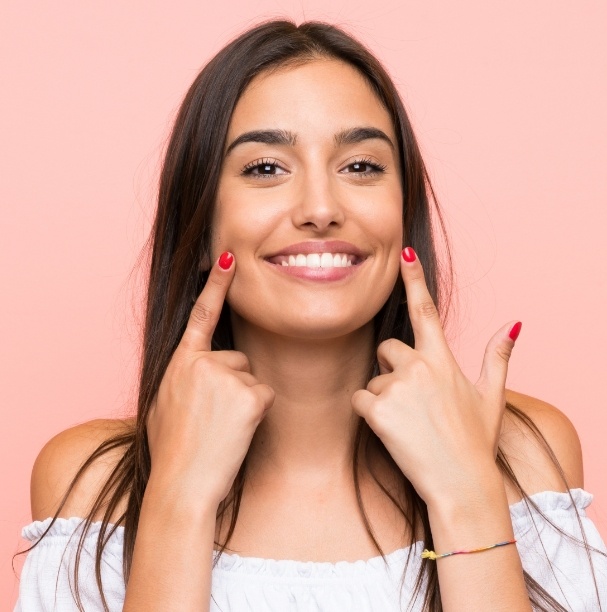 woman pointing to white smile