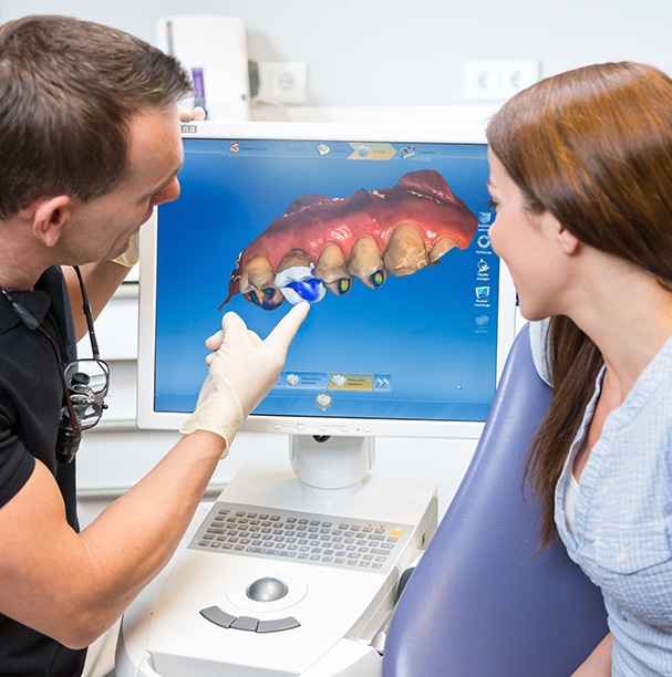 dentist pointing to cerec machine