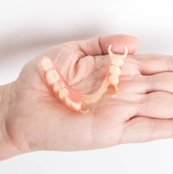 hand holding partial denture