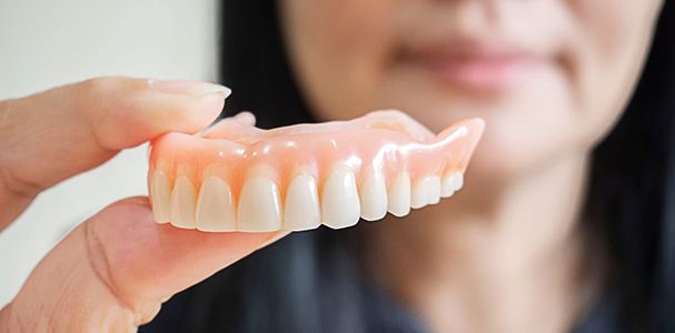 Woman holding dentures