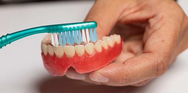 Man brushing a denture