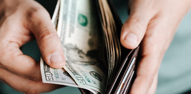 Man holding open wallet with cash