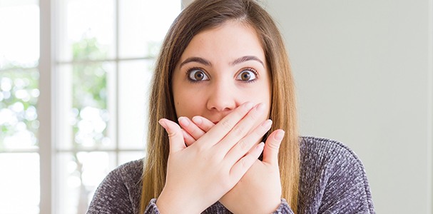 woman covering mouth with both hands