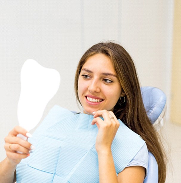 Happy patient admiring results of gum recontouring treatment