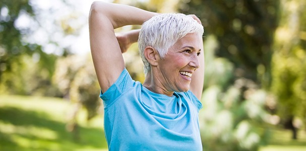 Woman smiling while stretching outside