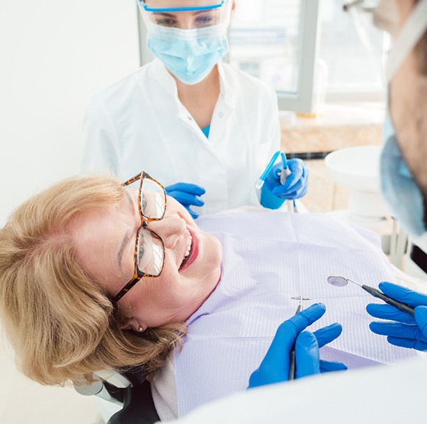 Woman smiling at dentist while sitting in treatment chair