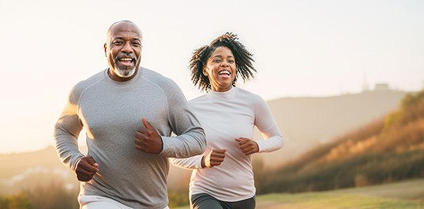 Smiling couple running on mountain trail