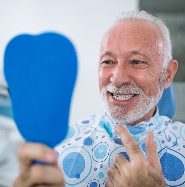 man checking smile in blue mirror