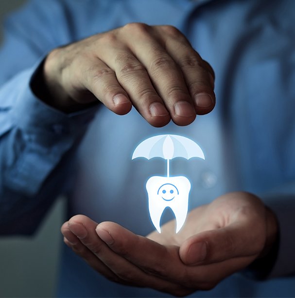 hand holding tooth with umbrella