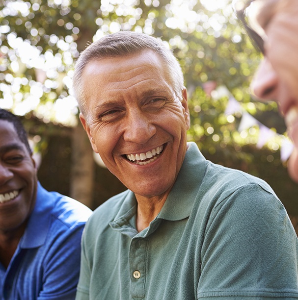 man laughing with friends outside