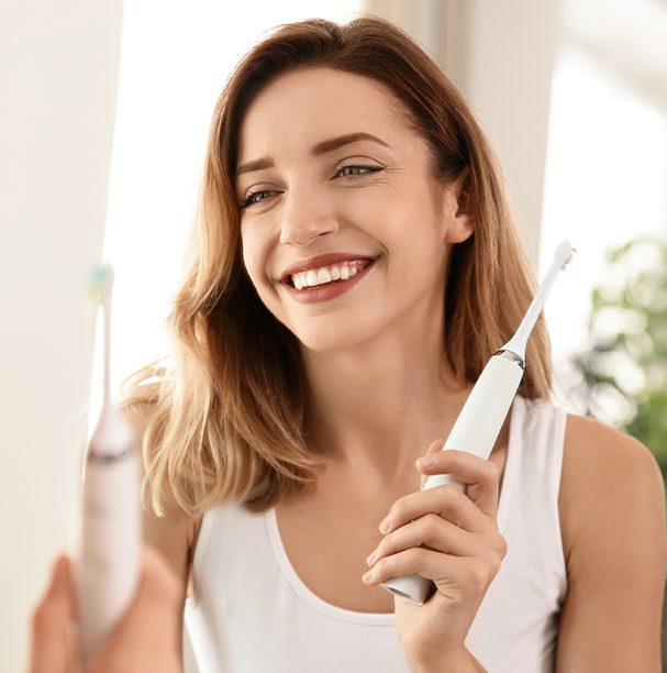 woman holding toothbrush smiling