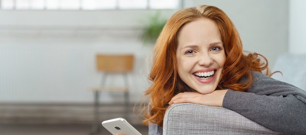 woman laying on couch smiling