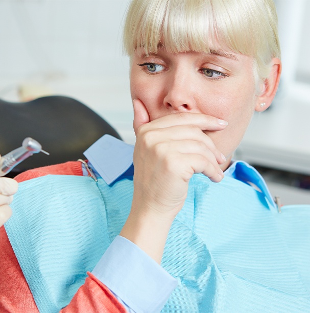 woman covering mouth scared