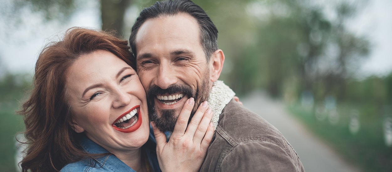 man and woman laughing cheek to cheek