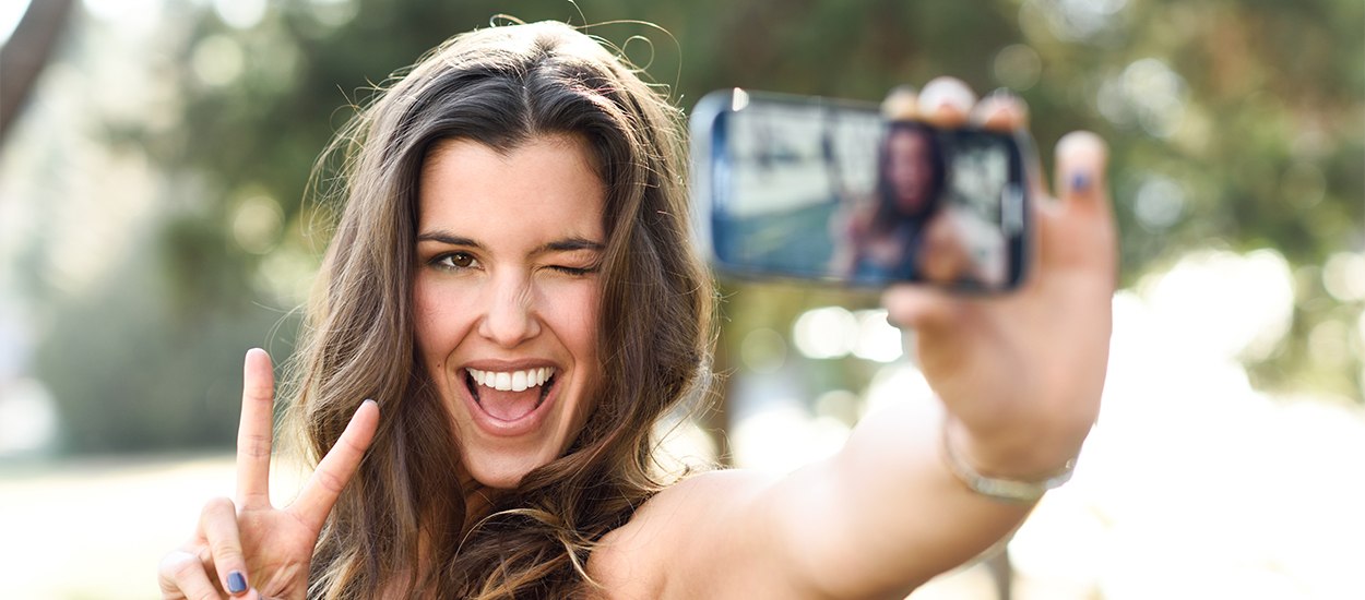 woman doing peace sign taking selfie