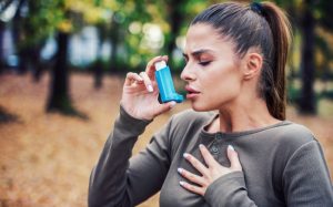 woman with asthma using her inhaler 