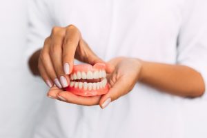 Woman holding full dentures
