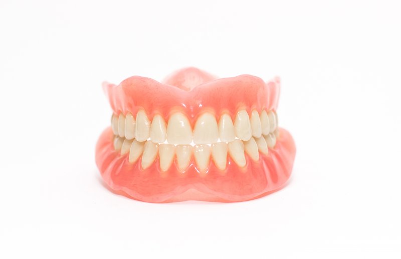 Two acrylic dentures set against white background