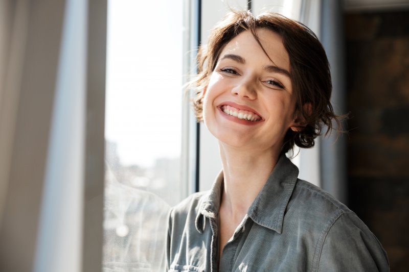 A woman smiling with her new dental implants